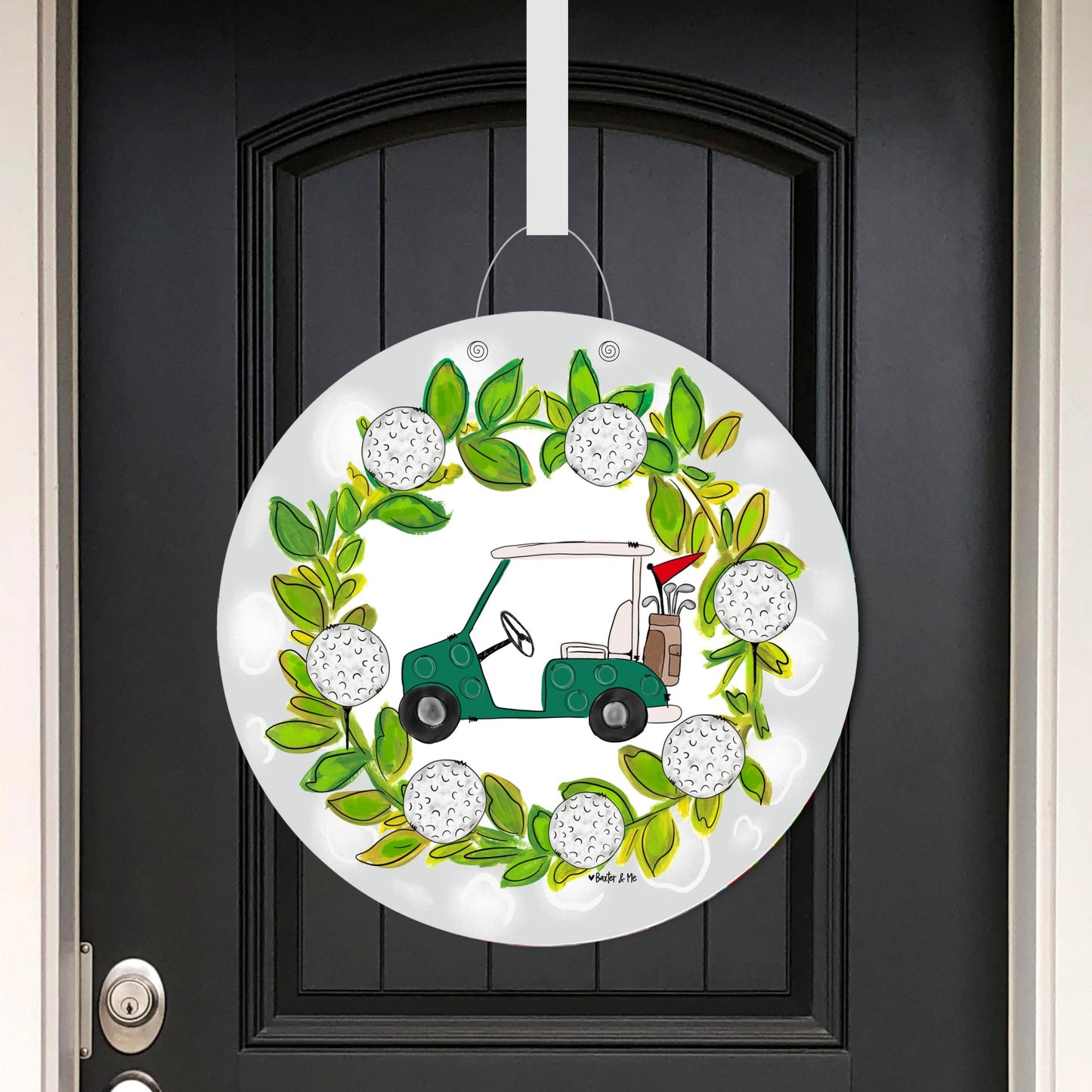 Decorative door hanger featuring wreath with golf cart and balls on a black door