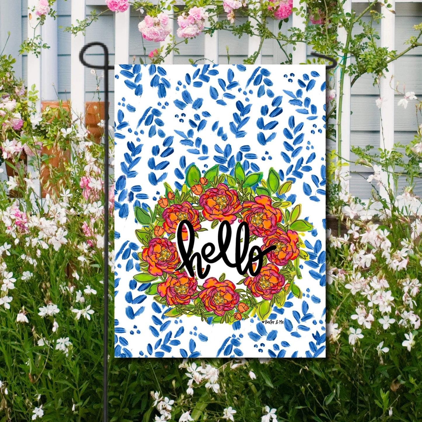 Decorative sign with floral design and 'hello' text, surrounded by flowers and greenery.