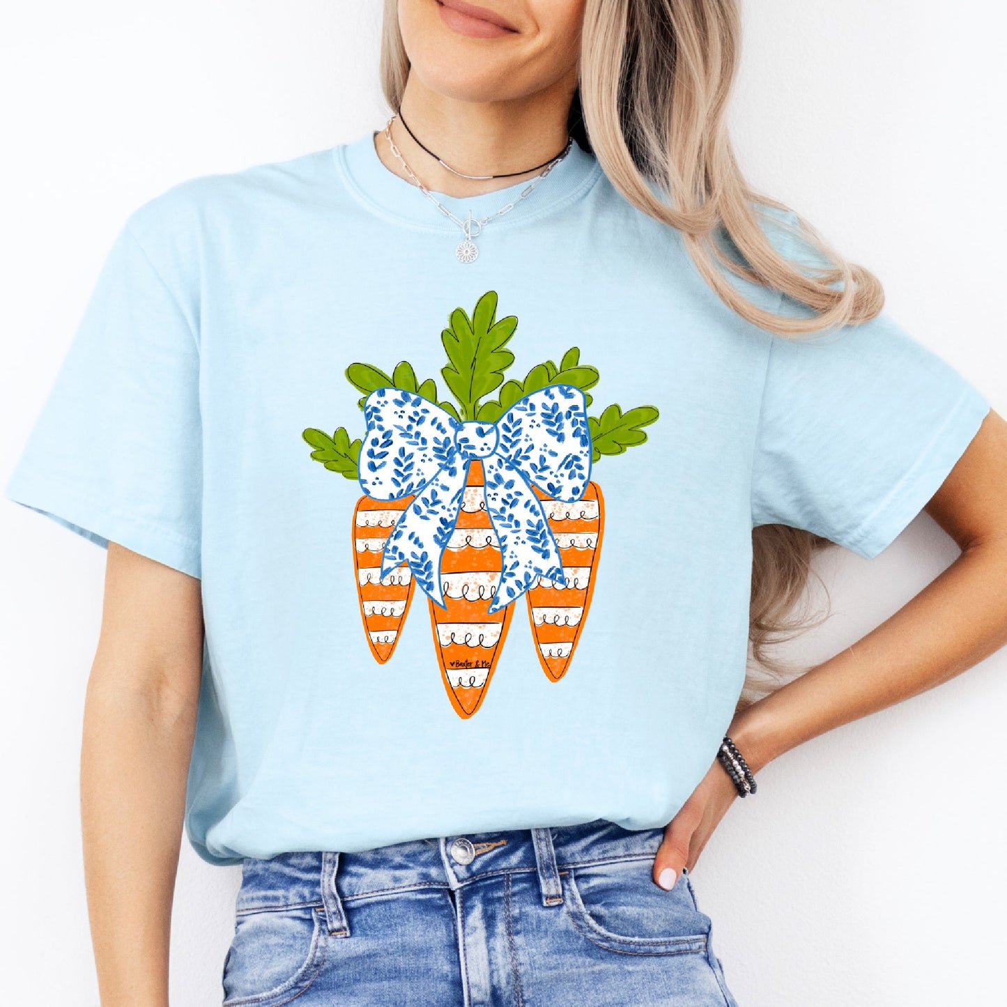 Person wearing a light blue t-shirt with a decorative carrot design on a white background