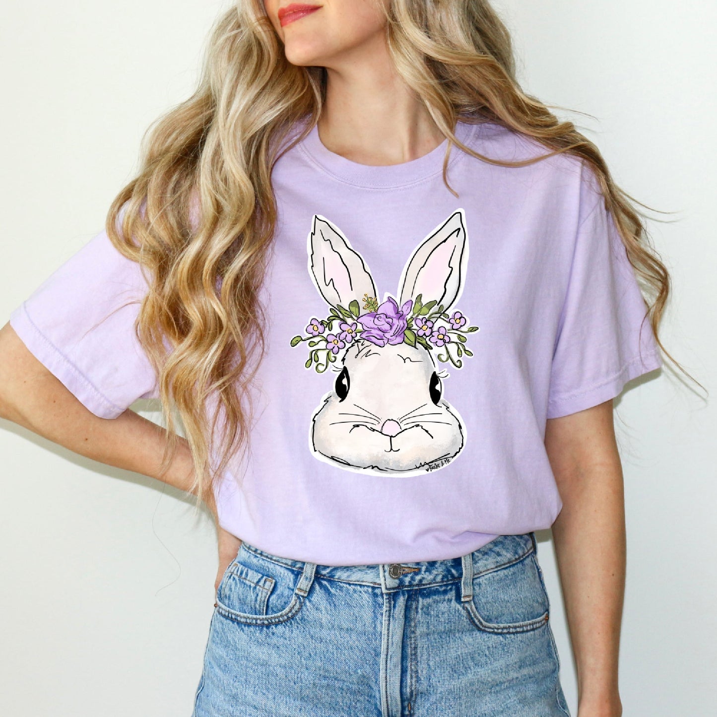 Person wearing a light purple t-shirt with a bunny graphic design.