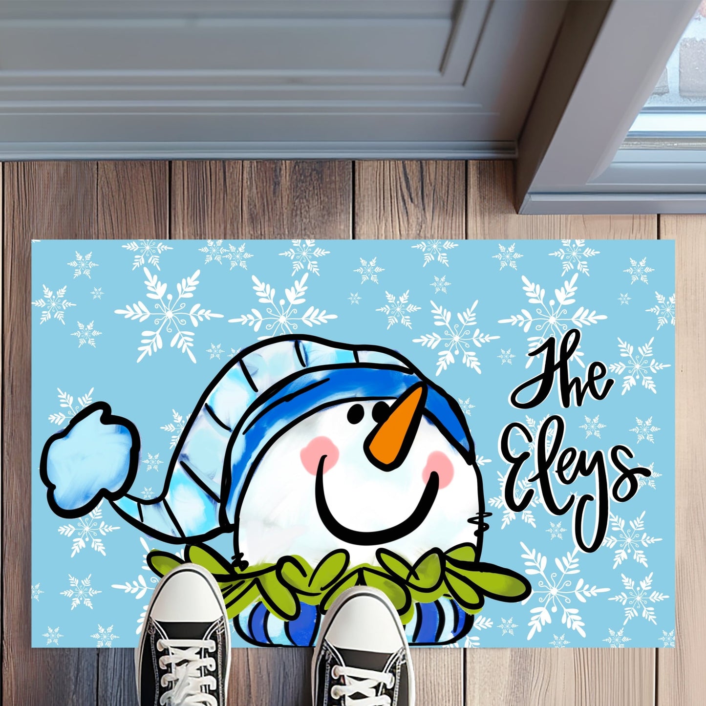 Doormat with a snowman design and personalized text on a wooden floor.