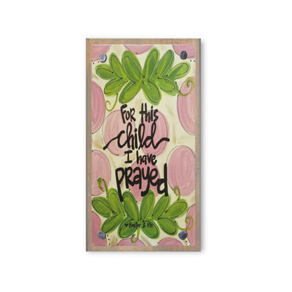 A wooden block with a printed design featuring leaves and the text 'For this child I have prayed' (Psalm 13:2).