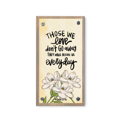 A wooden block with a printed floral design and a sentimental quote about loved ones.