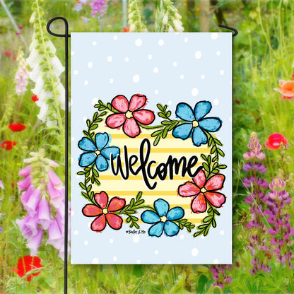 Decorative garden flag with colorful flowers and 'Welcome' text, set against a natural background of flowers.