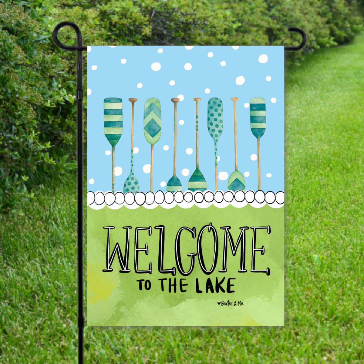 Decorative garden flag with oars and 'Welcome to the Lake' text on a grassy background