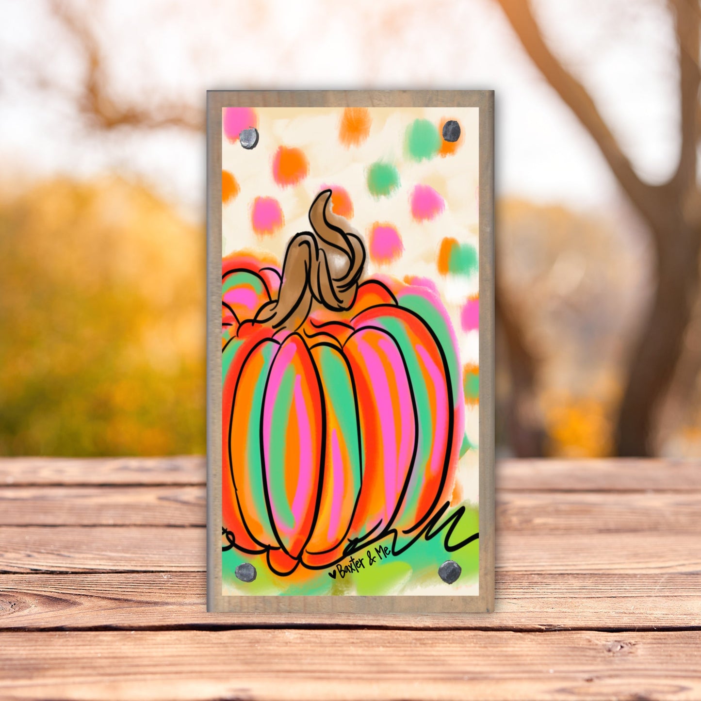 Colorful pumpkin painting on a wooden surface with a blurred outdoor background