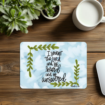 Placemat with motivational quote on a wooden table with plants and a mug.