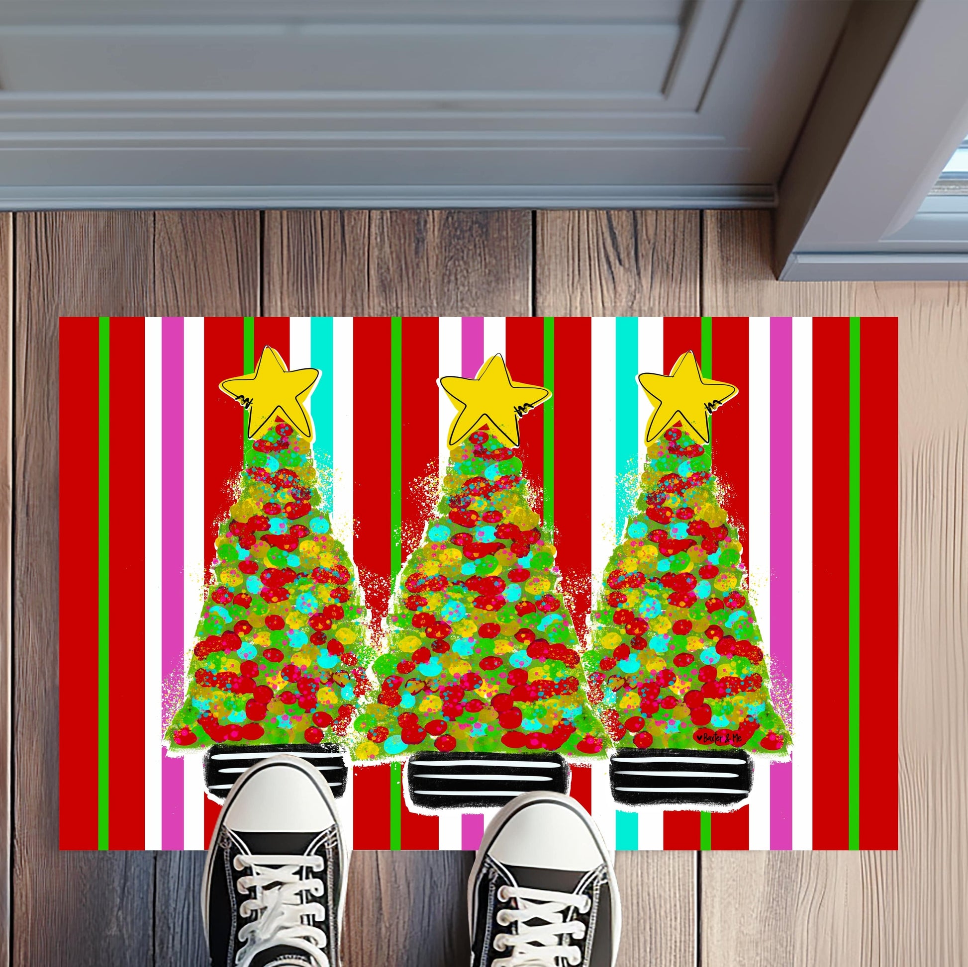 Colorful Christmas-themed doormat with trees and stars on a wooden floor.