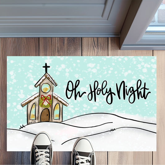 Decorative doormat with a Christmas design featuring a church and 'Oh Holy Night' text on a wooden floor.