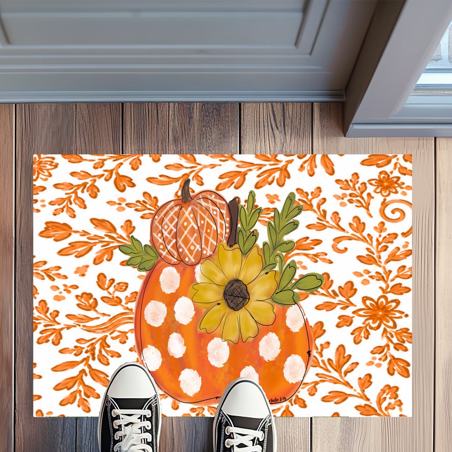 Decorative doormat with pumpkins and sunflower design on a wooden floor.