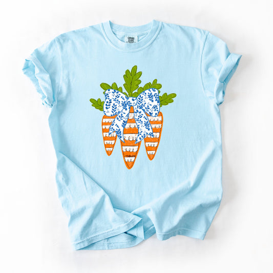 Light blue t-shirt with a decorative bow and carrot design on a white background