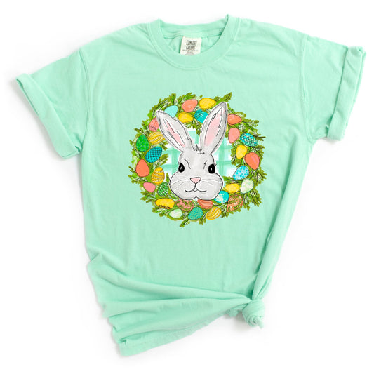 Mint green t-shirt with a bunny and Easter eggs design on a white background