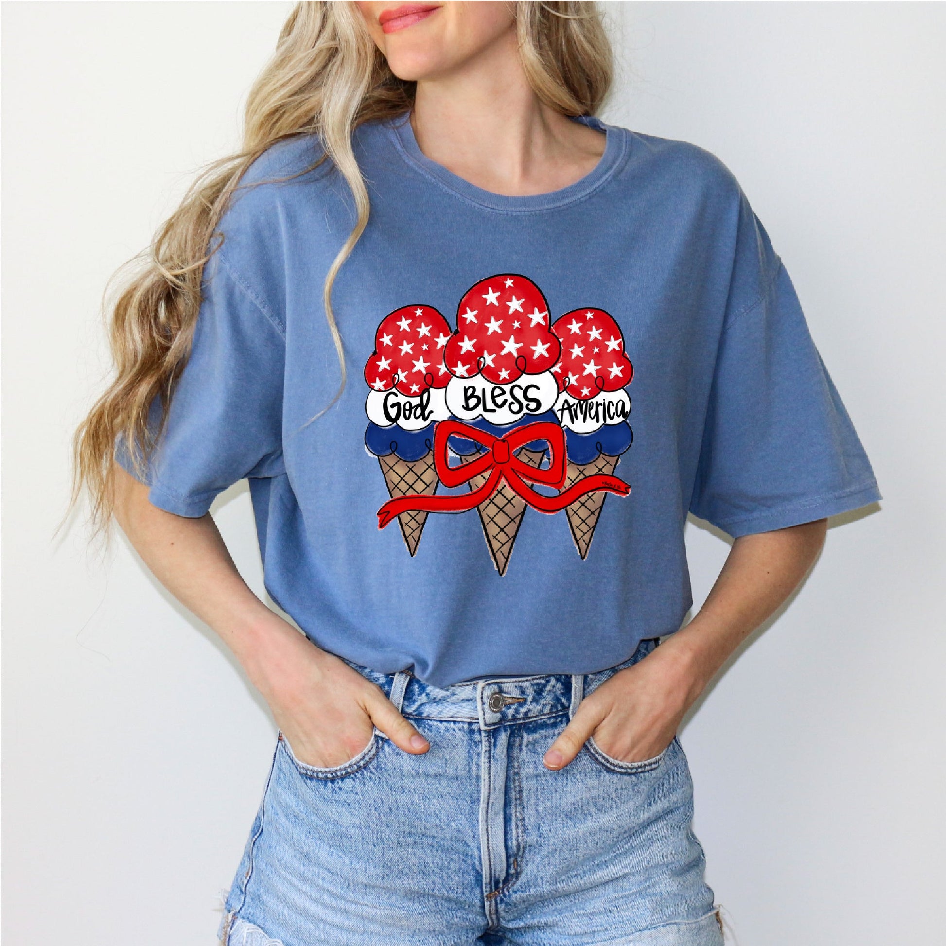 Person wearing a blue t-shirt with ice cream cone graphic and 'God Bless America' text.